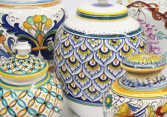 Vasi e lampade in ceramica siciliana dipinta a mano con motivi tradizionali blu, gialli e verdi.