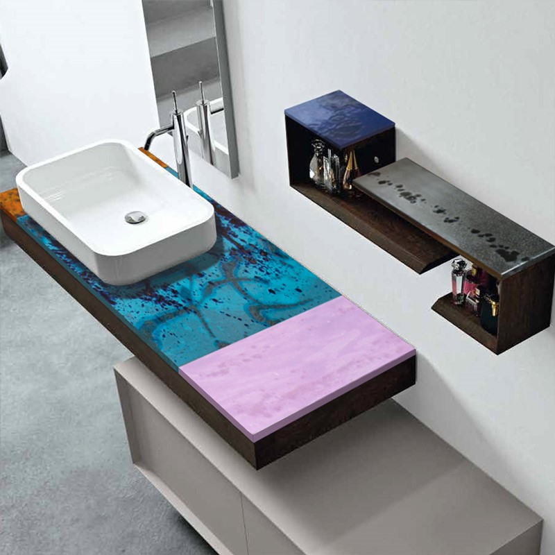 Lavabo moderno con piano d'appoggio artistico blu e rosa, mensole in legno scuro con profumi.