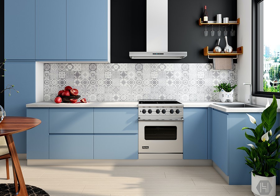 Cucina moderna blu e nera con piastrelle decorative, fornello in acciaio inossidabile e piante verdi.