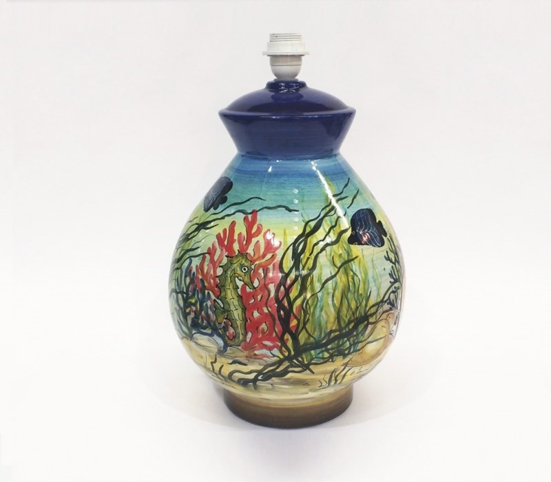 Base lampada in ceramica dipinta a mano con cavalluccio marino, coralli e vita marina su fondo blu e sabbia.