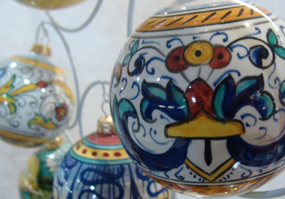 Palle di Natale in ceramica siciliana dipinte a mano con motivi floreali e geometrici vivaci.