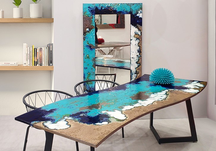 Tavolo e specchio in resina epossidica con design ispirato alla spiaggia e al mare in un interno moderno.