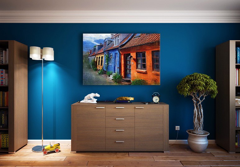 Interno moderno con parete blu, credenza in legno, lampada e quadro di case colorate.