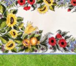 Tavolo in ceramica dipinta a mano con girasoli, papaveri, melograni e foglie verdi su erba.