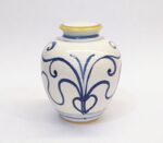 Vaso in ceramica bianco con decorazioni blu e bordi gialli, su sfondo chiaro.