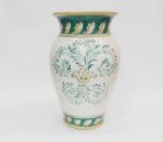 Vaso in ceramica bianca con decorazioni floreali verdi e gialle, bordo e base verdi.